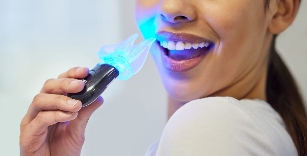 Teeth whitening, LED tool and mouth of patient, smile and treatment in office of dentist and closeup. Oral health, cleaning and equipment with light for tooth, healthcare and bleaching for person